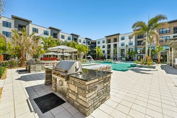 A pool area with a stone fountain in the middle of a patio.